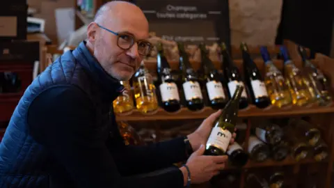 BBC Frédéric Brochet holds a bottle of non-alcoholic wine